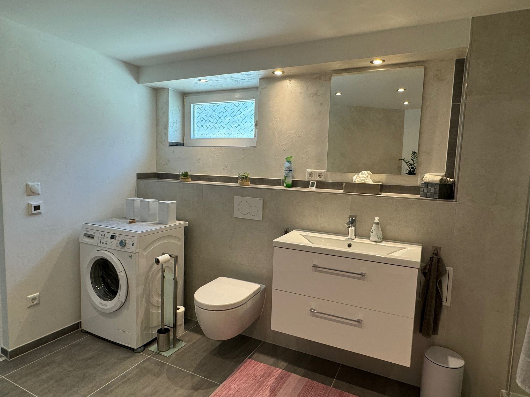 Badezimmer Überblick mit Waschmaschine, Toilette und Waschbecken